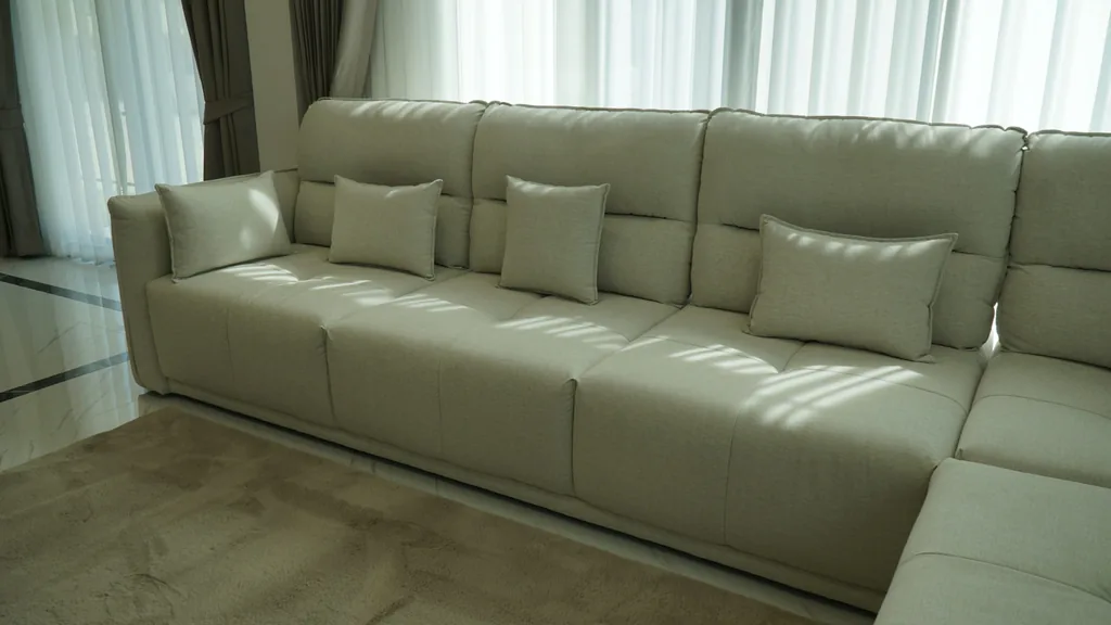 Grand canapé beige harmonisé avec une peinture murale claire dans un salon moderne et lumineux